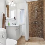 Bathroom with shower, sink, and washing machine.