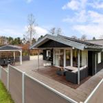 Modern villa with large outdoor area, terrace, and gazebo. Lawn and forest in the background.