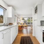 Kitchen with view to garden, dining area with table and chairs.