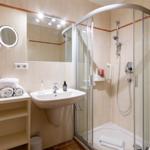 Badezimmer mit Dusche, Waschbecken und Spiegel