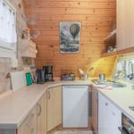 Küche mit Holzwänden, Arbeitsplatte, Spüle und Küchengeräten.
