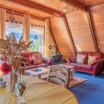 Wohnraum mit Holzwänden, rotem Sofa, Esstisch und Holztreppe.