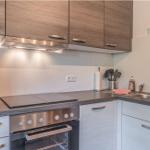 Küche mit Holzschränken, Herd und Spüle