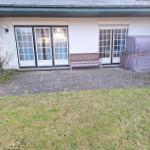 Hinterhof mit Sitzbank, Gartenterrasse und überdachtem Bereich.