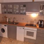 Küche mit grauen Schränken, Spüle, Kochfeld und integrierten Geräten.