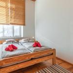 Schlafzimmer mit Holzbett, Fenster mit Jalousie und zwei Nachttischen.