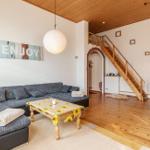 Wohn- und Essbereich mit Sofa, Tisch und Holztreppe.