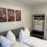 Schlafzimmer mit Bett, Kleiderschrank und Wandbildern