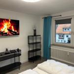 Zimmer mit Bett, Fernseher und Fenster mit Blick auf Dächer.