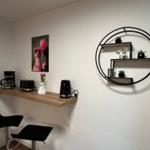 Küchenzeile mit Kaffeemaschine, Toaster und Wasserkocher. Wandregal mit Pflanzen und Gewürzen.