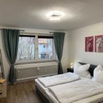 Schlafzimmer mit Doppelbett, Fenster, TV und Wandbildern von Lamas.