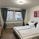 Schlafzimmer mit Doppelbett, Fenster, Vorhängen und Wandbildern von Lamas.