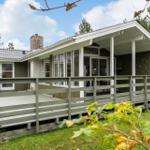 A house with a terrace and wooden veranda in the green.