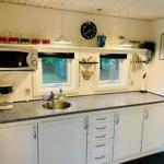 Kitchen with white cabinets, countertop, and windows to the garden.