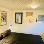 Bedroom with bed, wall art, and hat rack on the wall.