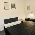 Bedroom with bed, wall art, and nightstand