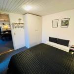 Bedroom with bed, wardrobe, and pictures on the wall.