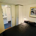 Bedroom with bed, wardrobe, and adjacent bathroom.