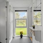 Entryway with window, mirror, and vase with sunflowers.