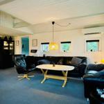 Living room with black leather furniture, wooden table, and yellow pendant lamp.