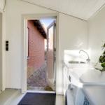 Backyard with washing machine and sink. Entrance to the kitchen.