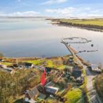 House by water with view of harbor and fields