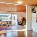 Kitchen with white cabinets and dining area with wooden table and chairs.