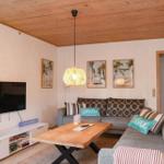 Living room with sofa, wooden table, and TV mounted on the wall.