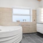 Bath with whirlpool, window, and sink with mirror