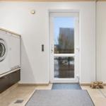 Entrance area with washing machine, door, and floor covering