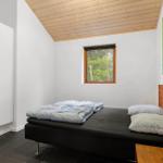 Bedroom with bed, wardrobe, and window to the forest.