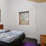 Bedroom with bed, wall art, and window for tree view.