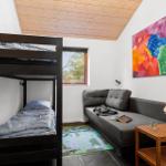 Room with bunk bed, sofa, and colorful wall art.
