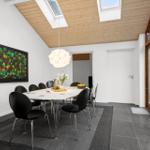 Dining room with table, chairs, skylights, and wall art.
