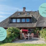 Haus mit Strohdach, Terrasse mit Gartenmöbeln und Rosengesträuch. Modernisiert ab 2026. Hunde willkommen.