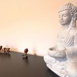 Buddha-Statue mit kleinem Figuren-Set auf dunklem Tisch