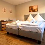 Schlafzimmer mit Doppelbett, Nachttischen und Wandbildern.