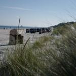 Strand mit Sandkörben und Dünen gras. Blick auf das Meer und Ferienhaus.