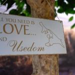 Schild mit Motiv Usedom hängt an einem Baum.