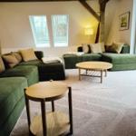 Grüner Sofa-Set mit Holztischen und großen Fenstern im Wohnzimmer.