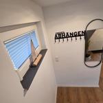 Eingangsbereich mit Spiegel, Kleiderhaken und Fenster mit Segelbootmodell.