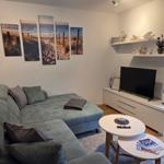 Wohnzimmer mit Sofa, TV und Wandbildern