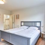 Schlafzimmer mit Doppelbett, Kleiderschrank und Nachttisch mit Lampe.