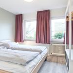 Schlafzimmer mit Doppelbett, Fenster und Kleiderschrank.