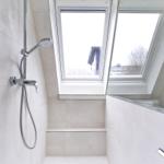 Dusche mit Dachfenstern und Glaswand in modernem Badezimmer.