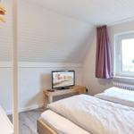 Zimmer mit Doppelbett, Fernseher und Fenster mit Blick nach draußen.