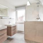 Badezimmer mit zwei Waschbecken, Dusche und Fenster.