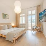 Schlafzimmer mit Bett, TV und Balkontür.