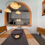 Essbereich mit Tisch, Stühlen und Blick in die Küche.