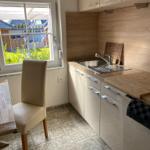 Küche mit Holzoberflächen, Spüle und Blick auf Garten.